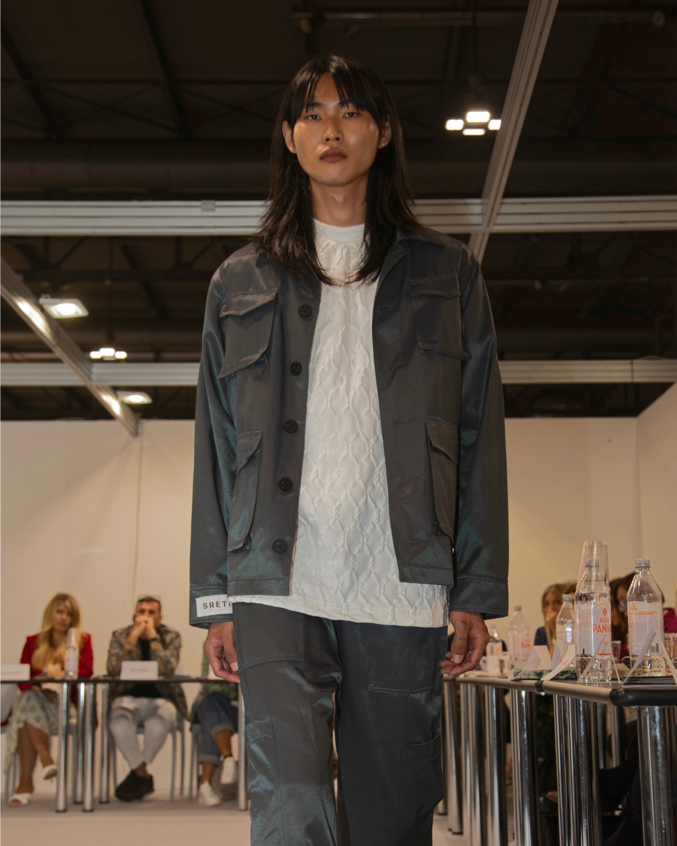 Model wearing jacket, t-shirt, and pants from KOVARI collection.