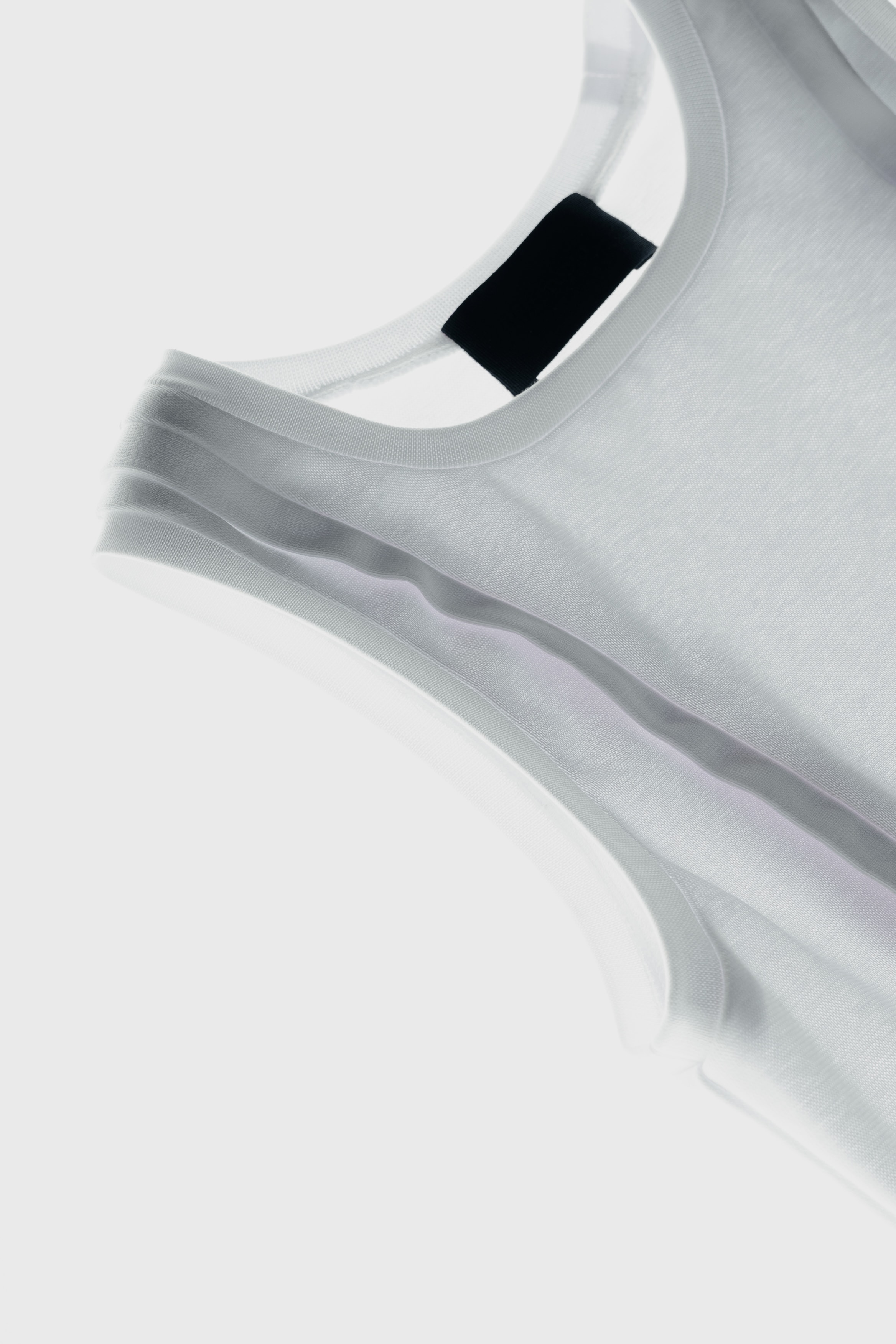 Close-up detail of knitted tank top showing tape finishing along the edges.